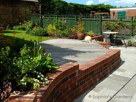 A curved brick dwarf wall set into a patio leads to  .